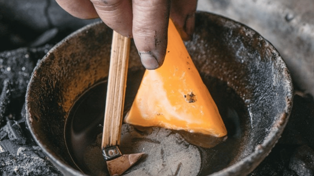 Beeswax heated and melted on a traditional charcoal stove