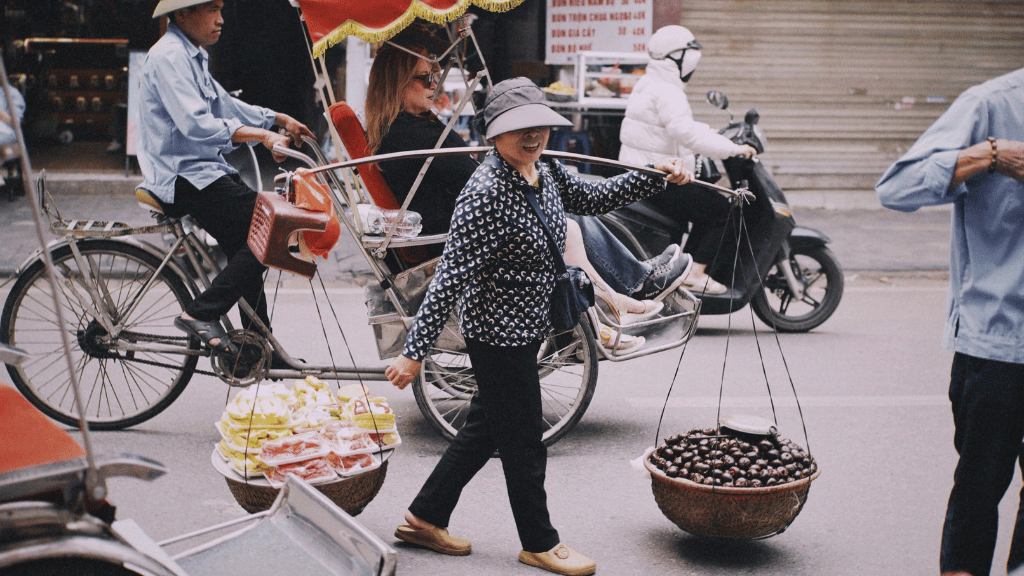 Hanoi street vendors carrying traditional shoulder poles (gánh hàng rong)